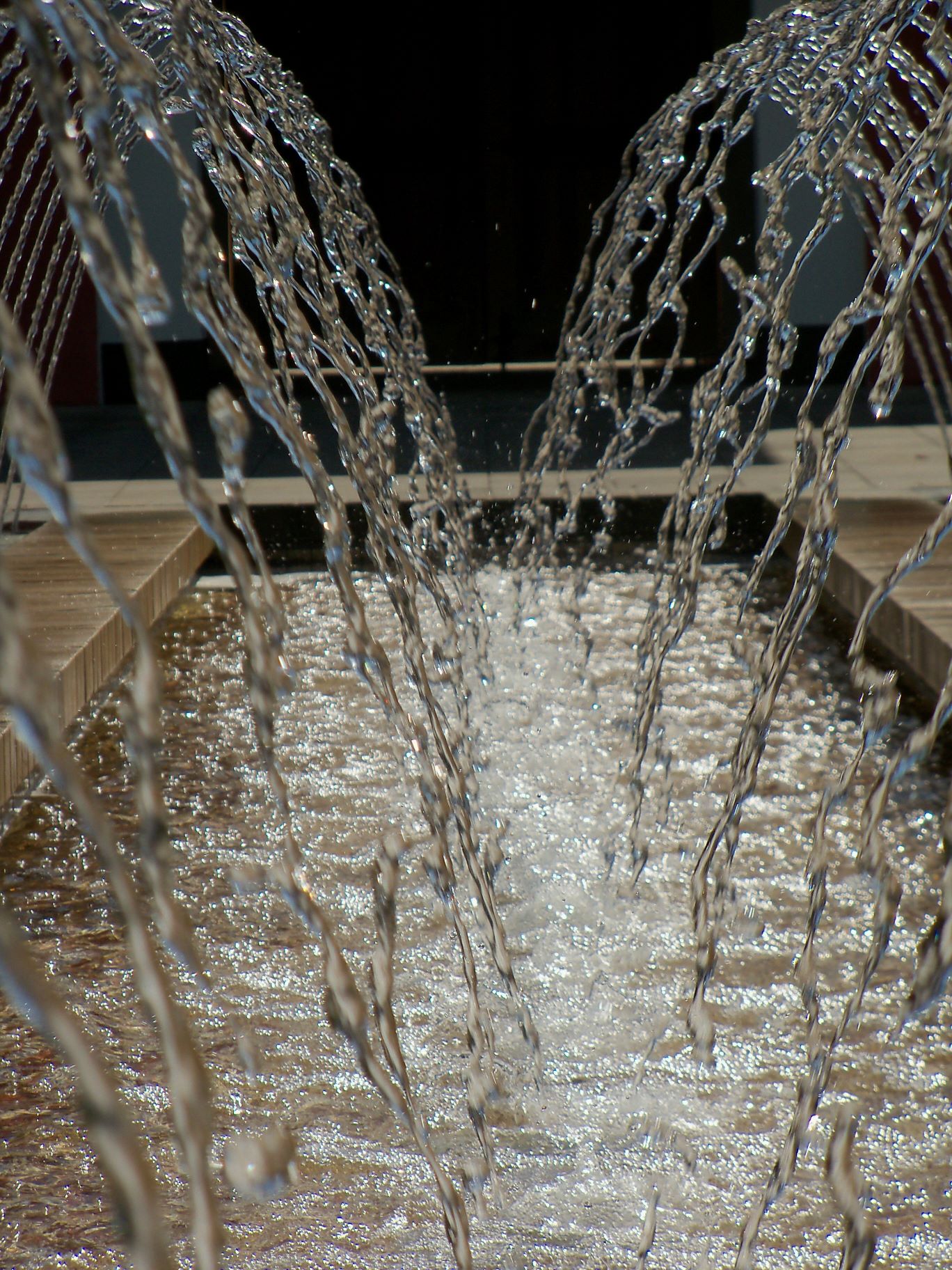 Wasser, das von links und rechts oben in eine Rinne in der Bildmitte fließt